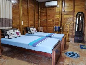 two beds in a room with wooden walls at Sea View Resort in Kallady