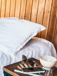 a table with glasses and a bowl on a bed at Joly Tiny House in Overijse