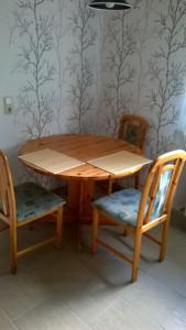 a wooden table with two chairs and a table and a wall at Ferienwohnung Ahoi in Putbus +3 photos