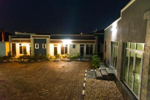 a house at night with a cobblestone courtyard at AVISHA TOWN HOTEL in Kigali