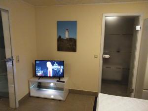 a room with a television and a bed and a door at Ferienwohnung Ahoi in Putbus