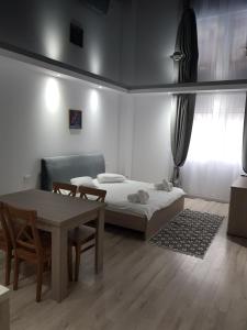 Un dormitorio con una cama y una mesa y sillas. en Happy Residence, en Vişeu de Sus