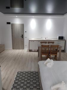 Zimmer mit einer Küche, einem Tisch und einem Bett in der Unterkunft Happy Residence in Vişeu de Sus