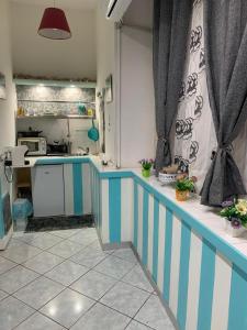 une cuisine avec des bandes bleues et blanches sur les comptoirs dans l'établissement Posidonia, à Pouzzoles