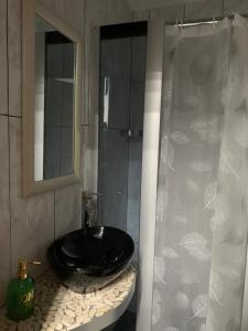 La salle de bains est pourvue d'un lavabo noir et d'une douche. dans l'établissement Posidonia, à Pouzzoles
