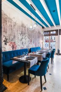 a dining room with blue chairs and a mural at Logis Hotel Restaurant Le Cheval Blanc in Bléré