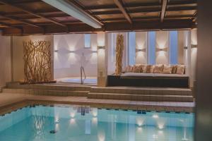 a pool in a hotel with a bench and a tub at Kunzmann's Hotel | Spa in Bad Bocklet