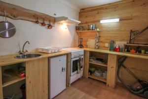 eine Küche mit Holzwänden, einer Spüle und einem Herd in der Unterkunft Calm studio in the historical centre - Dodo et Tartine in Guillestre