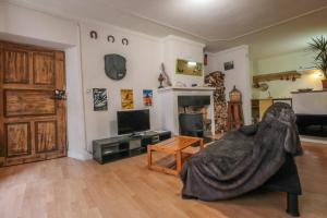 ein Wohnzimmer mit einem Sofa und einem TV in der Unterkunft Calm studio in the historical centre - Dodo et Tartine in Guillestre
