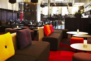 a restaurant with couches and tables with colorful pillows at Scandic Aarhus City in Aarhus