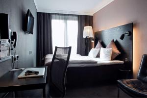 a hotel room with a bed and a desk and a room at Scandic Front in Copenhagen