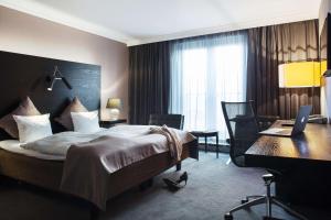 a hotel room with a bed and a desk with a laptop at Scandic Front in Copenhagen