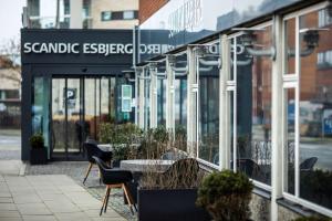 einen Tisch und Stühle vor einem Gebäude in der Unterkunft Scandic Olympic in Esbjerg