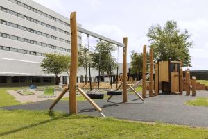 un patio de juegos vacío frente a un edificio en Scandic Hvidovre en Hvidovre