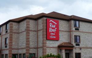 a red rock inn and suites sign on the side of a brick building at Red Roof Inn & Suites Detroit - Melvindale/Dearborn in Melvindale