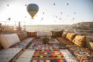 a hot air balloon flying over a couch with a table at Nessa Cave Hotel in Göreme