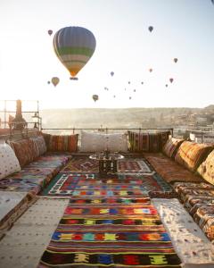 a hot air balloon flying over a pile of colorful carpet at Nessa Cave Hotel in Goreme