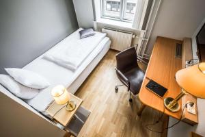 Kleines Zimmer mit einem Bett, einem Schreibtisch und einem Stuhl in der Unterkunft Scandic The Mayor in Arhus
