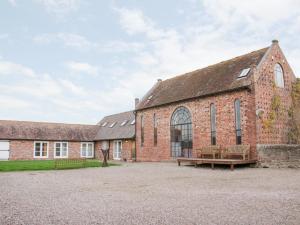 ein altes Backsteingebäude mit einer Bank davor in der Unterkunft Windy Mundy Farm in Shrewsbury