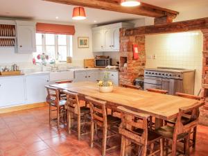 a large kitchen with a wooden table and chairs at Windy Mundy Farm in Shrewsbury