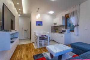 ズラティボールにあるApartman Gavrilov 3のソファとテーブルのあるキッチンとリビングルーム +9枚の写真