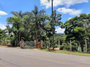 a fence on the side of a road with trees at Recanto dos Passaros in Socorro