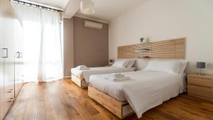 two beds in a bedroom with white walls and wooden floors at Italianway - Riva di Reno 47 B in Bologna