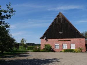 ein großes rotes Backsteingebäude mit schwarzem Dach in der Unterkunft Landhaus Holthausen in Werne an der Lippe
