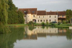 ein großes Haus mit einem See davor in der Unterkunft la ferme, Coeur De Combray in Ernes