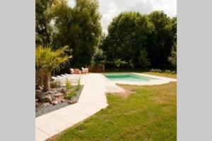 a swimming pool in a yard with trees and grass at la ferme, Coeur De Combray in Ernes +20 photos
