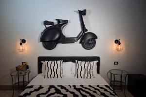 uma scooter pendurada numa parede acima de uma cama em Thairè Resort em Castel Volturno