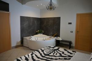 uma casa de banho com uma banheira e um tapete com estampa de zebra em Thairè Resort em Castel Volturno