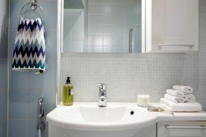 y baño con lavabo blanco y espejo. en Central, peaceful, high-end apartment en Helsinki