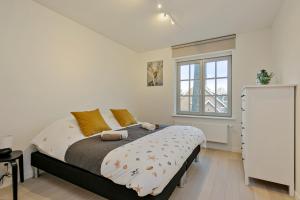 une chambre avec un grand lit et une fenêtre dans l'établissement Villa Josephine, à Coxyde