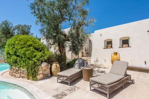 a patio with two chairs and a swimming pool at Il Trullo - Tia Maria Country Inn in Racale