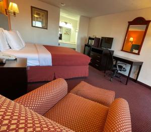 Habitación de hotel con 2 camas, escritorio y sillas en Antilley Inn, en Abilene