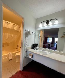 y baño con lavabo, aseo y espejo. en Antilley Inn, en Abilene