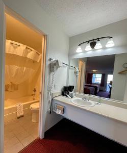 a bathroom with a sink and a toilet and a mirror at Antilley Inn in Abilene