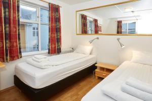 two beds in a room with a mirror at Reykjavik Downtown Hotel in Reykjav&iacute;k