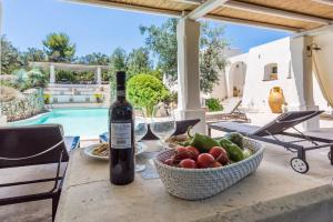 a table with a bottle of wine and a bowl of fruit at Trilocale 101-tia Maria Country Inn in Racale