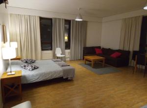 a hotel room with a bed and a couch at Hostel Vekotin in Toijala