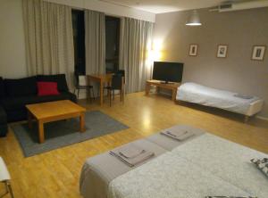 uma sala de estar com um sofá e uma cama em Hostel Vekotin em Toijala