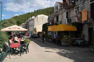 una calle con mesas y sillas y un edificio en Apartment Ivan, en Račišće