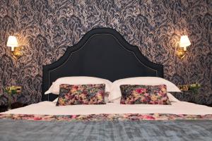 a bed with two pillows and two lamps on it at Fitzpatrick Castle Hotel in Dalkey