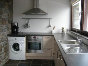 a kitchen with a washing machine and a sink at Le Fournil d Andrimont in Stoumont