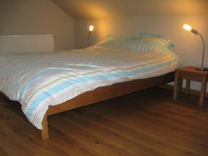 uma cama grande num quarto com 2 candeeiros em Le Fournil d Andrimont em Stoumont