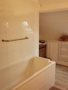 a white bath tub with a glass wall in a bathroom at Villa bord de mer avec piscine et jacuzzi in Pénestin