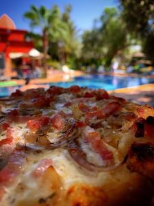 a pizza sitting on a table next to a pool at Le Relais De Marrakech in Marrakech