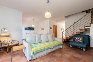 una camera con letto, sedia e scale di Villa Blue Garden by ALGARVEMANTA a Manta Rota
