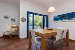 una sala da pranzo con tavolo e sedie in legno di Villa Blue Garden by ALGARVEMANTA a Manta Rota